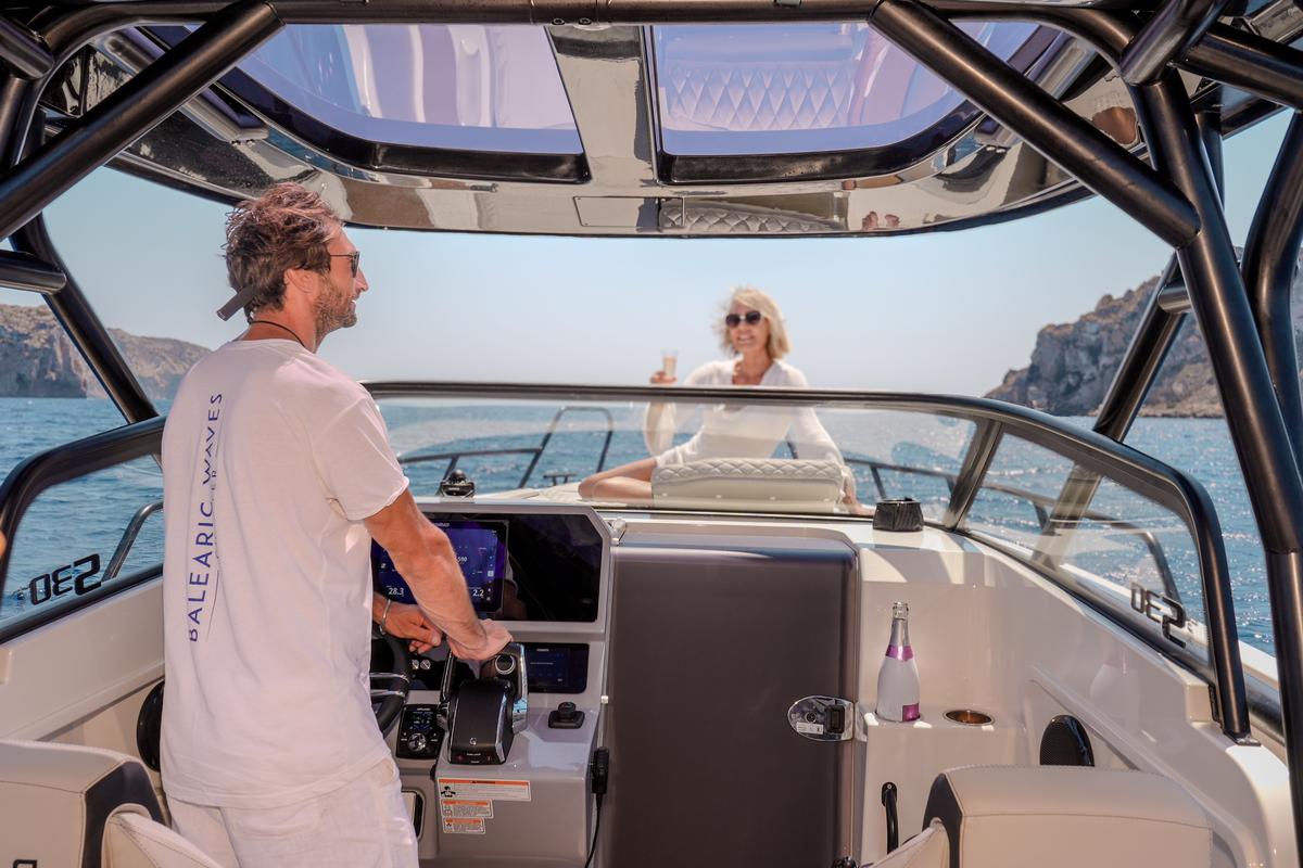 Professional captain at the helm of NAVAN S30 private charter boat in Ibiza with advanced navigation and Balearic Waves branding